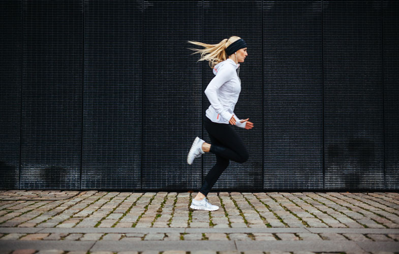 Young woman wearing workout gear and running