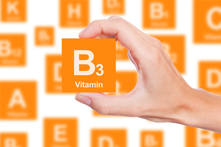 Hand holding cube with Vitamin B3 written on it